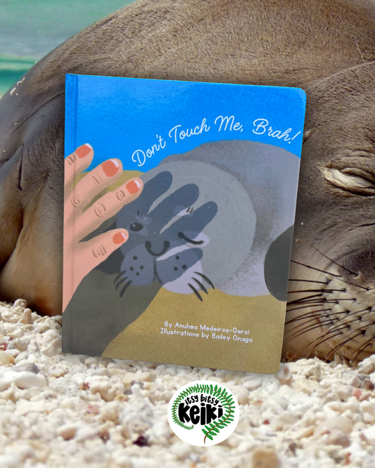 Seal lying on a beach with a book titled 'Don't Touch Me, Brah!' by Anuhea Medeiros-Gersi. Illustrations by Bailey Onaga of B.Miyo Art